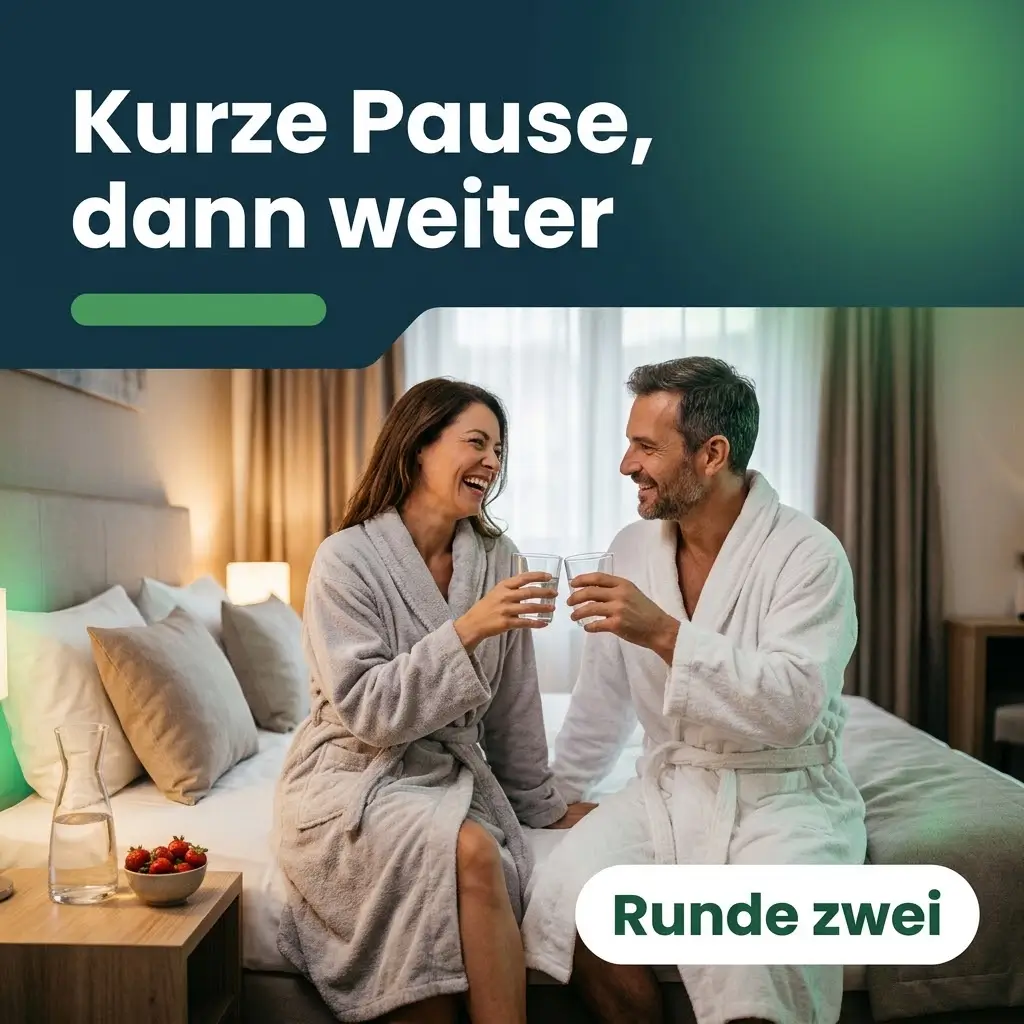 Paar in Bademänteln stößt lachend mit Wasser an, kurze Pause vor der zweiten Runde