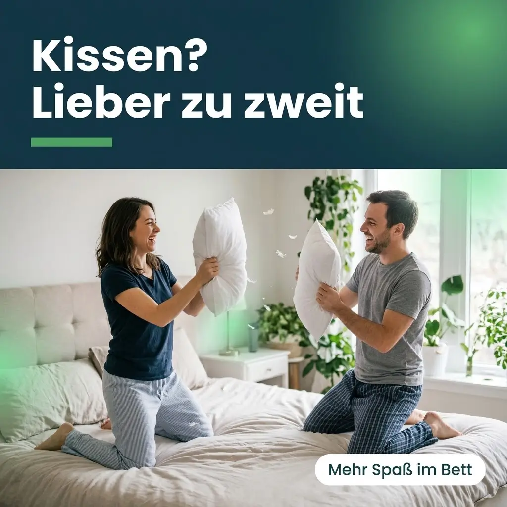 Paar macht lachend eine Kissenschlacht auf dem Bett